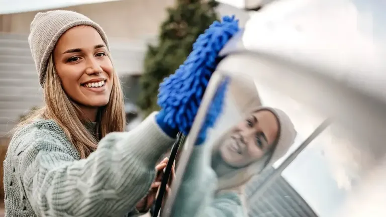 A woman cleaning her car