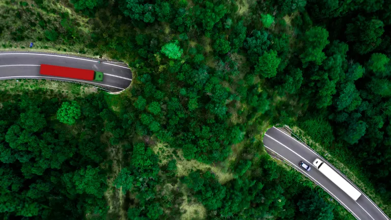 Red truck and white truck on a mountain highway